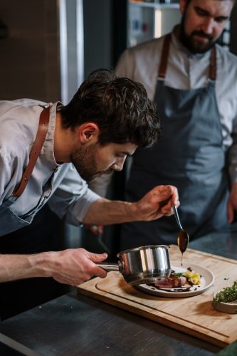 Foto van Enrico, Chef van Mia Casa. Hij is bezig met een bord aan het vullen met eten